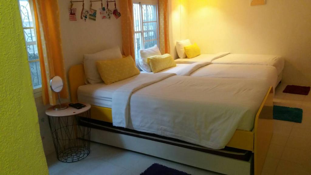 清莱纳拉克奥度假酒店的卧室配有一张带黄色枕头的大型白色床。
