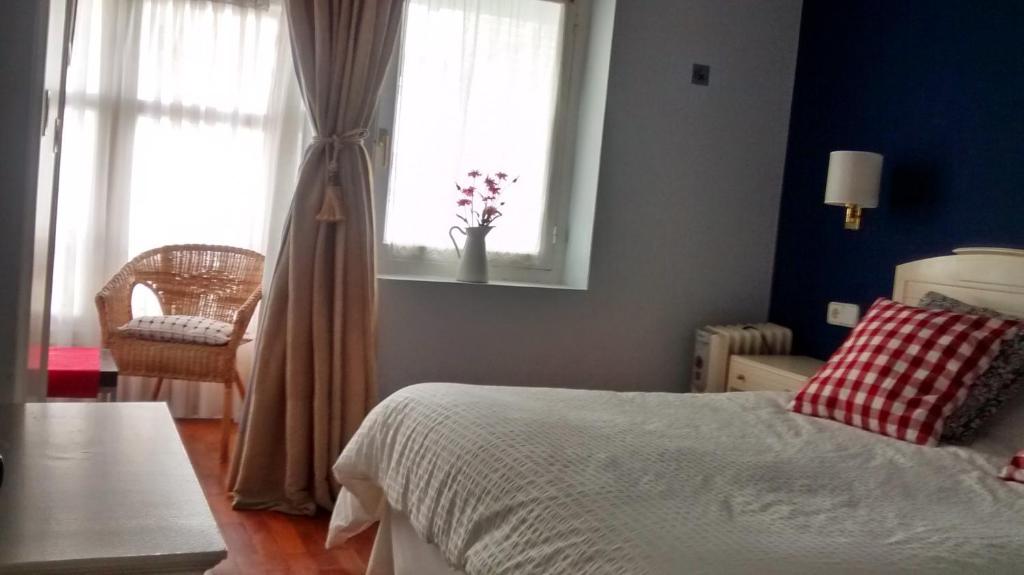 普伦西亚Casa de marinos UribeKosta的一间卧室设有一张床、一个窗口和一把椅子
