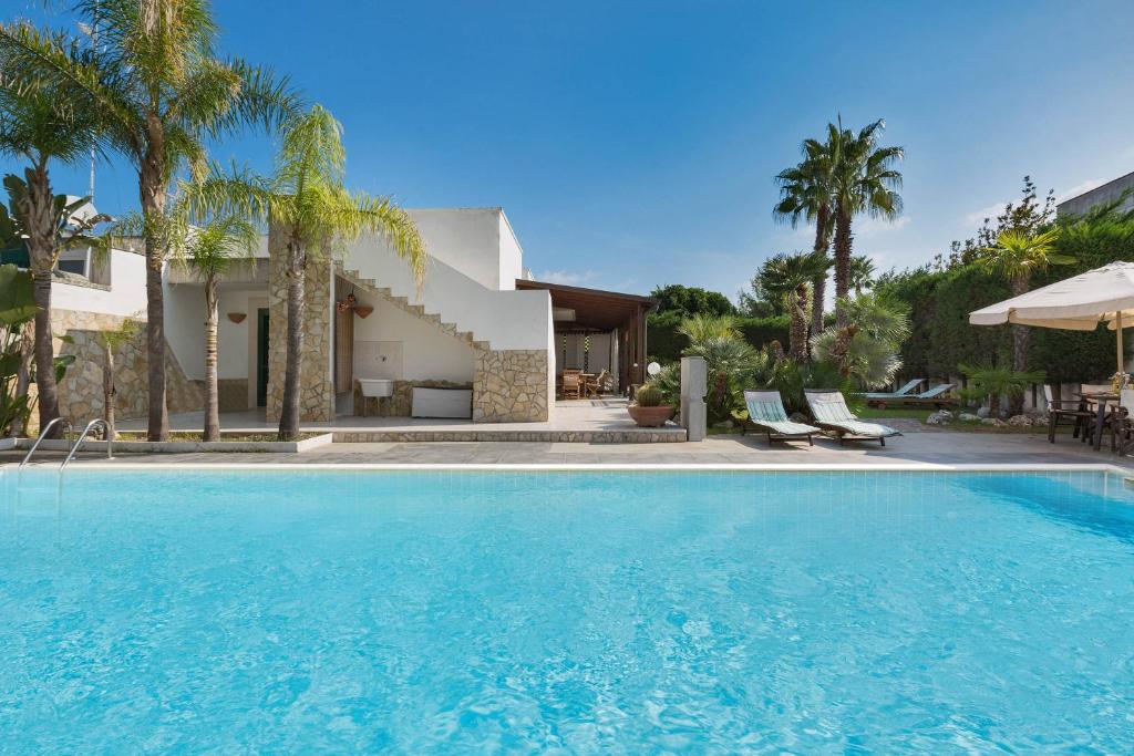 托里德欧索Villa Goccia by BarbarHouse的棕榈树屋前的游泳池