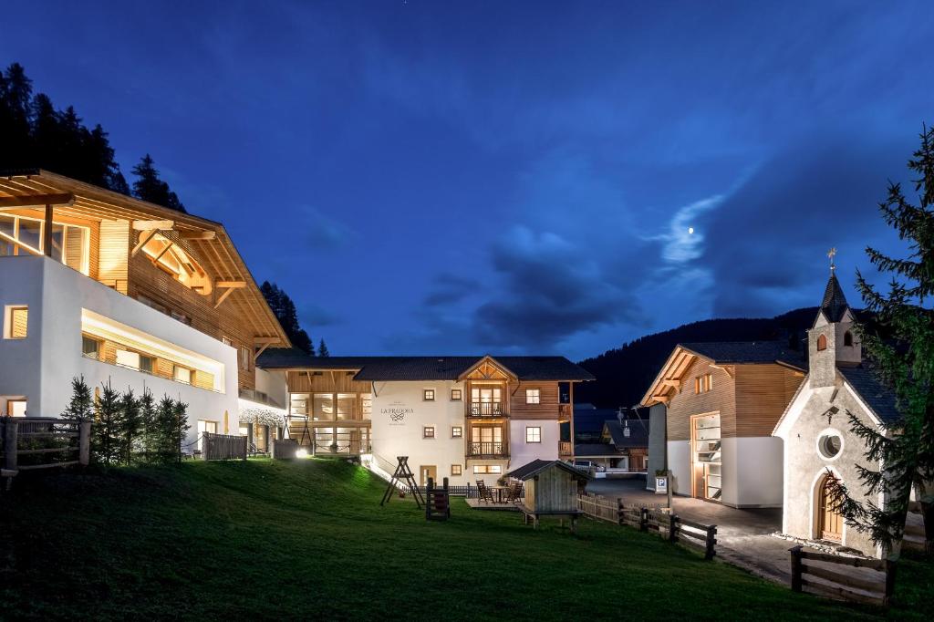 圣卡夏诺Hotel La Fradora - Dolomites Hotel的一座带教堂和庭院的大房子