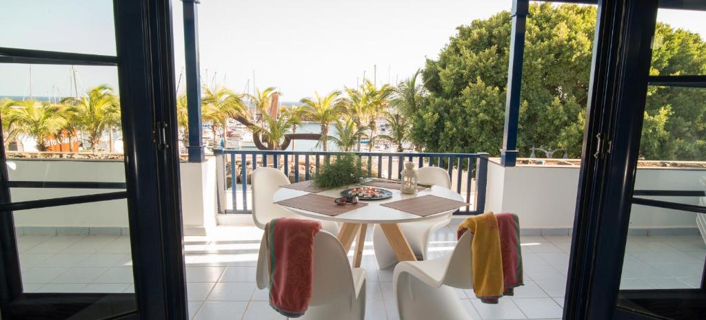 卡列罗港VistAgua的棕榈树阳台的桌椅