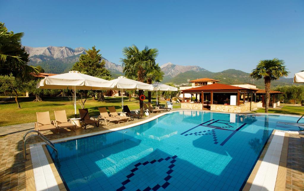 斯卡拉伯塔麦斯阿里亚丹尼简易别墅酒店的度假村内带椅子和遮阳伞的游泳池