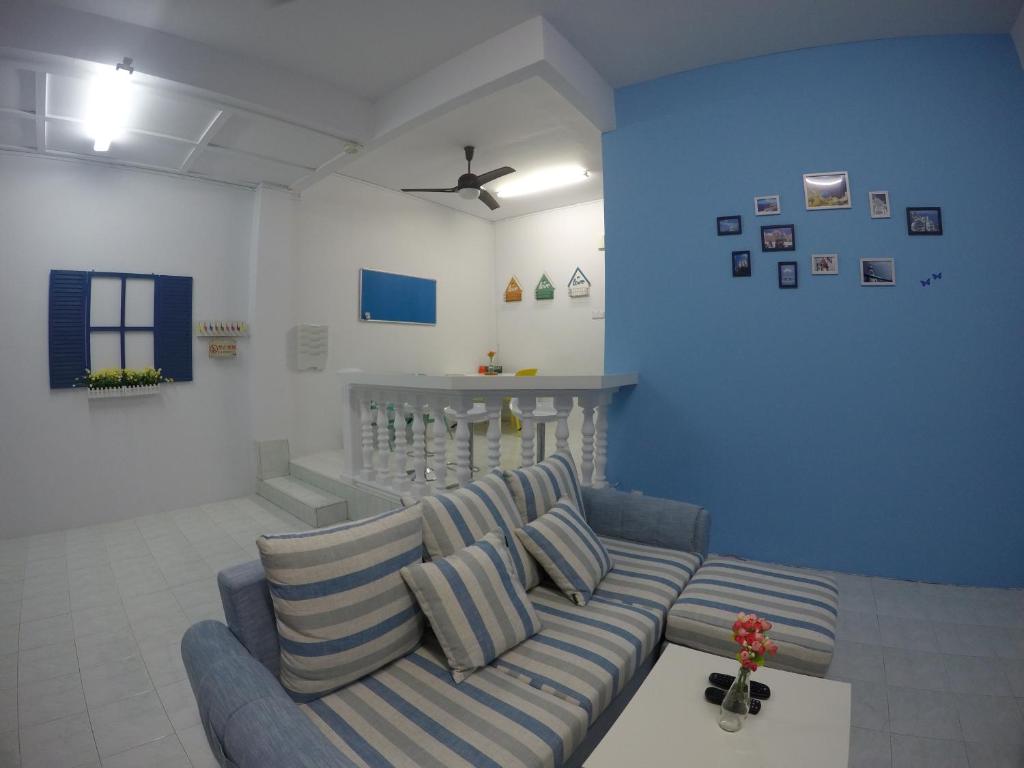 CukaiLittle Blue House Kemaman Guesthouse的带沙发和蓝色墙壁的客厅