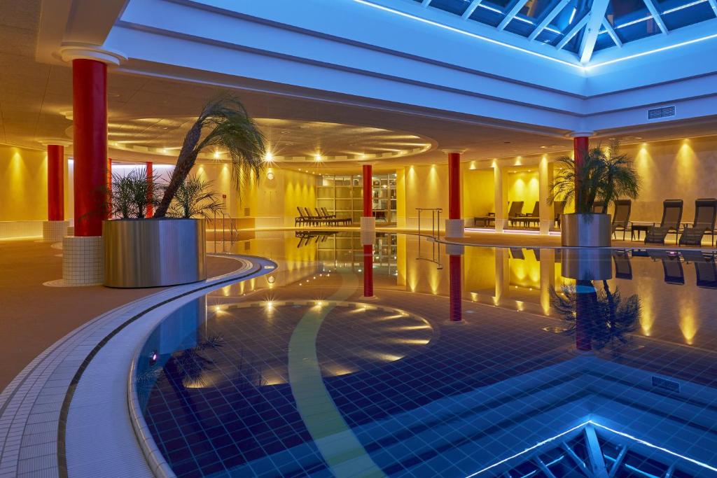 腓特烈罗达腓特烈罗达H+水疗酒店的酒店大堂,中间设有游泳池