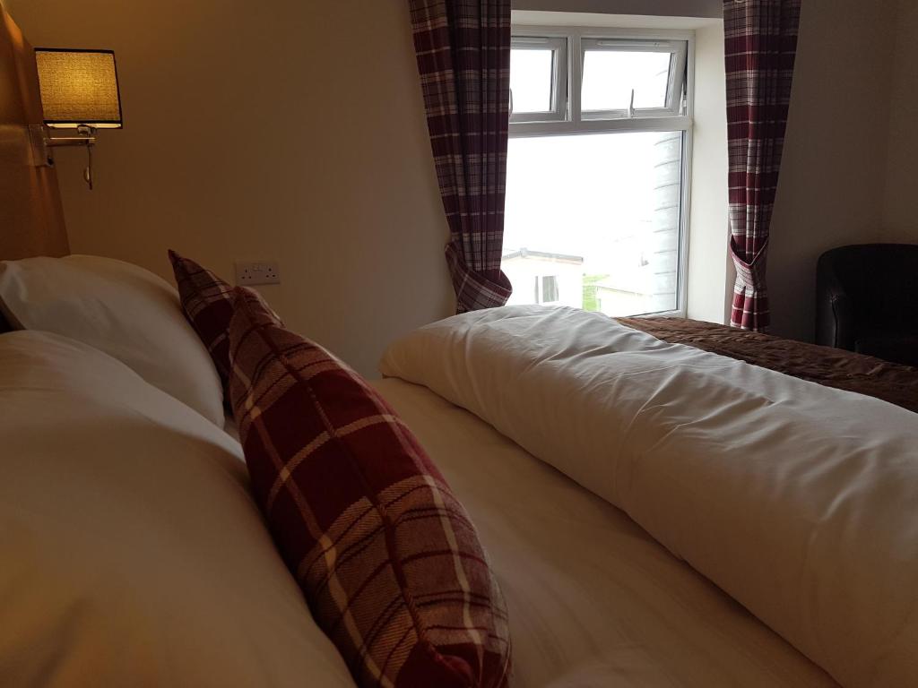 伯克顿The Cliff Top Inn的配有窗户的酒店客房内的两张床