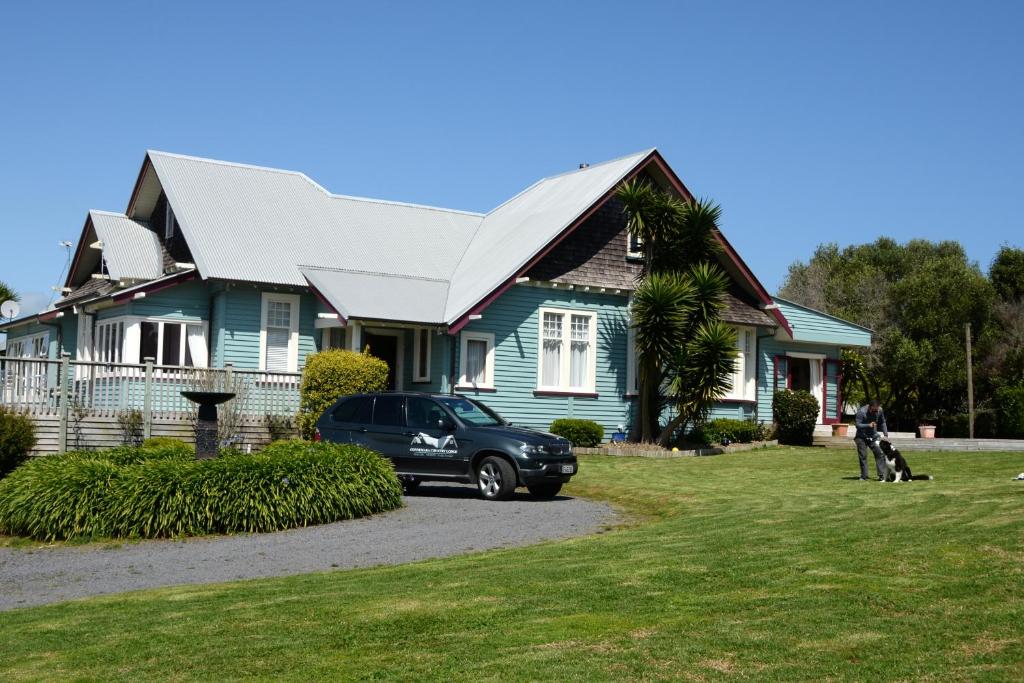 AwhituConnemara Country Lodge的前面有停车位的房子