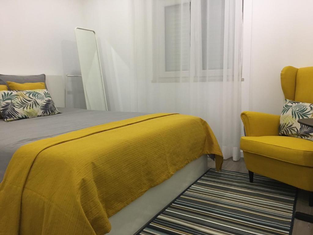里斯本Lisboa Comfort Apartment的一间卧室配有黄色的床和黄色的椅子