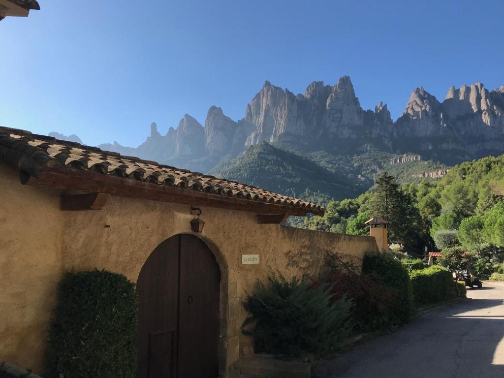 莫尼斯特罗尔Montserrat La Calsina的一座有门的建筑,背景是群山