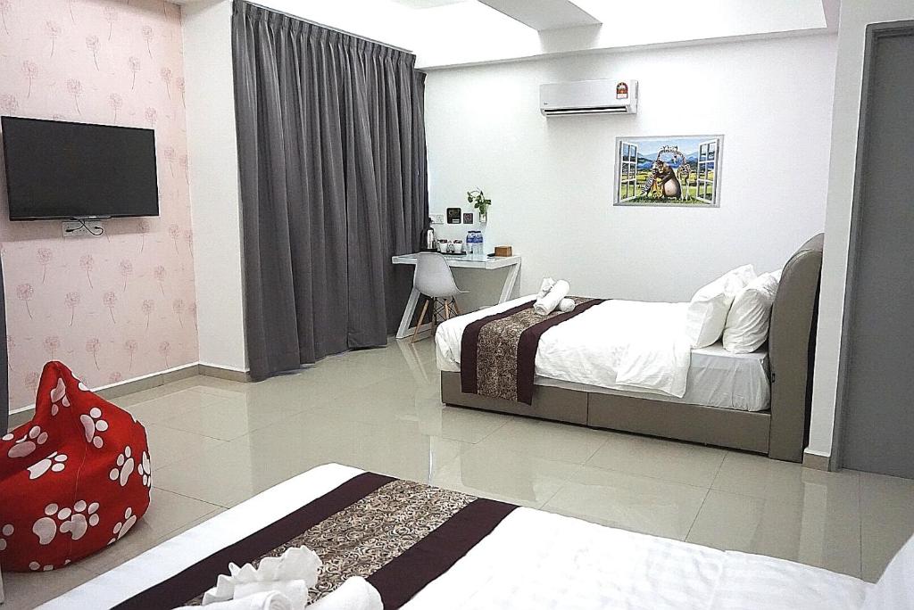 马六甲D舒适酒店的一间卧室配有一张床、一张书桌和一台电视。