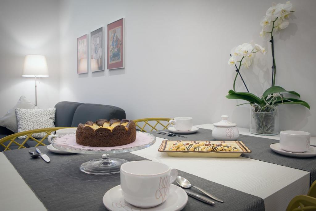 圣阿尔坎杰洛-迪罗马涅L'Appartamento del Corso的餐桌,带蛋糕和咖啡杯