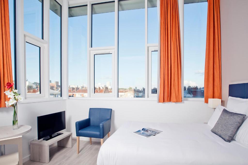 巴黎巴黎戴夫住宿及商务公寓酒店的酒店客房设有一张床、一台电视和窗户。