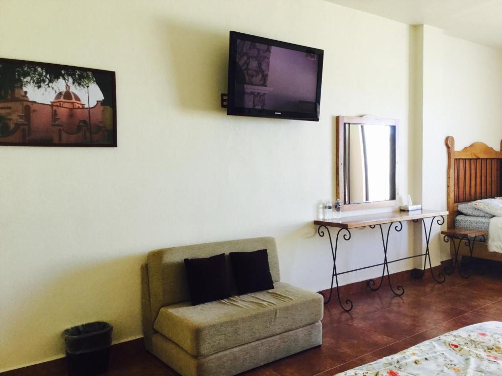 贝纳尔Hotel Mariazel的客厅配有椅子和墙上的电视