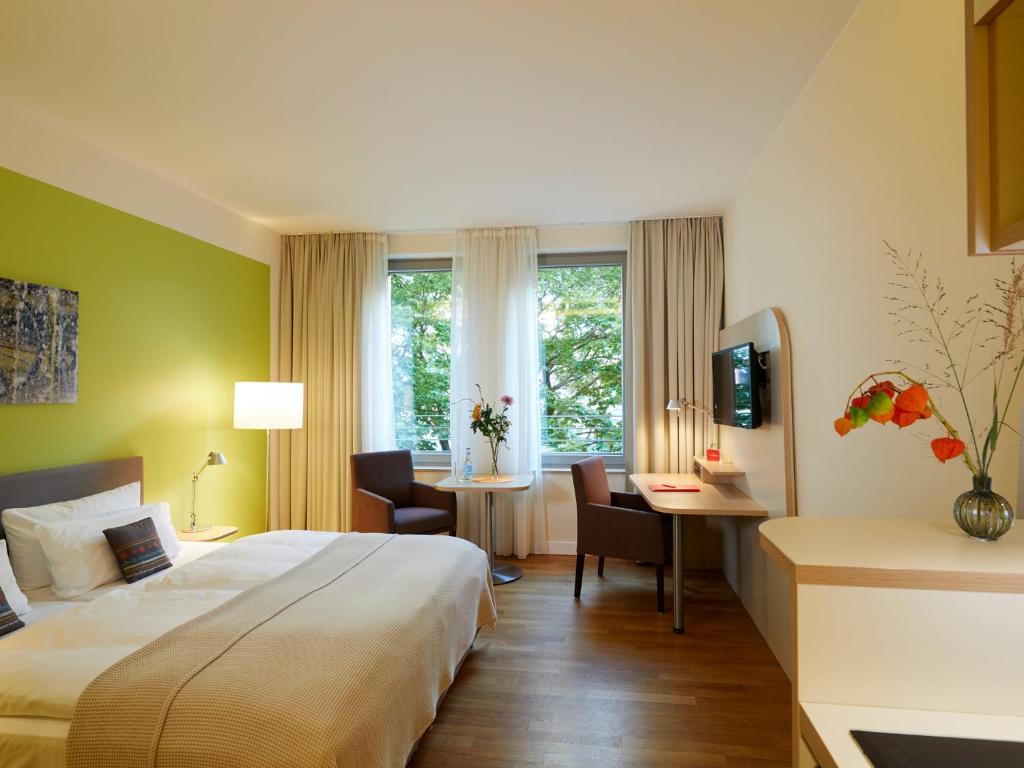 柏林柏林弗洛特维尔公园酒店的酒店客房设有一张大床和一张书桌。