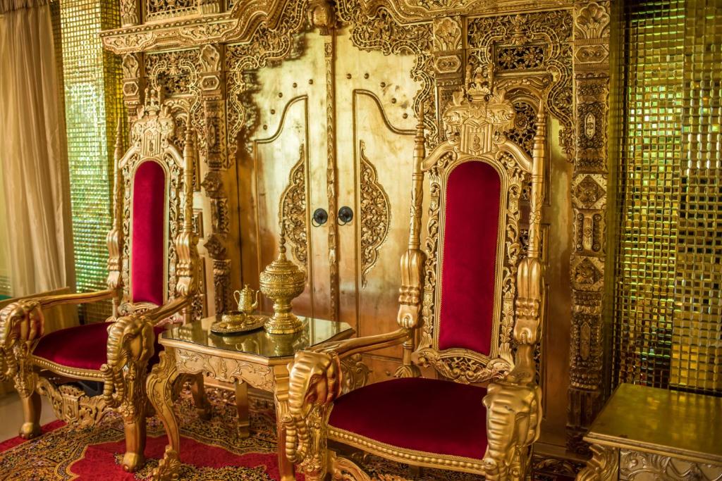 清莱Nakaraj Princess Chiang Rai - Walking Street的金宝座,位于带红色椅子的房间