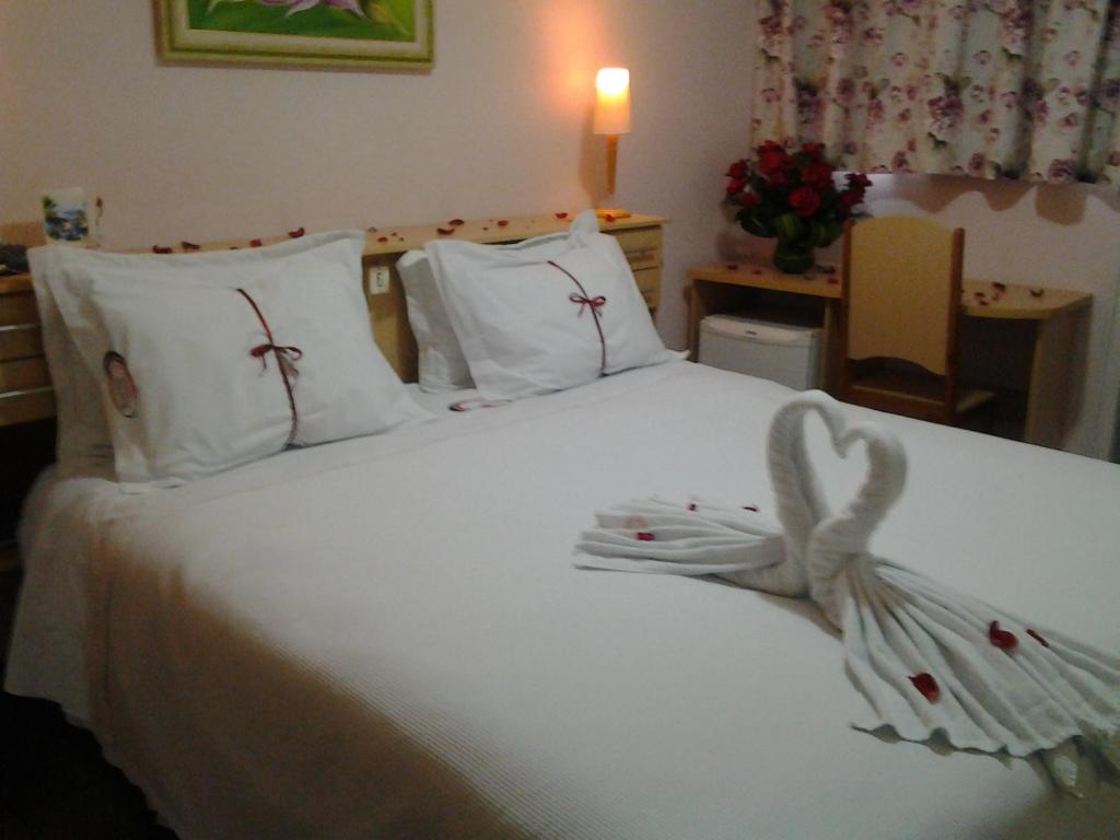 巴拉韦利亚Hotel Mirante的卧室配有白色的床,上面有弓