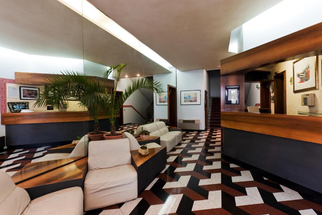 奥尔泰莱蒂齐亚酒店的一间客厅,配有白色家具和盆栽植物