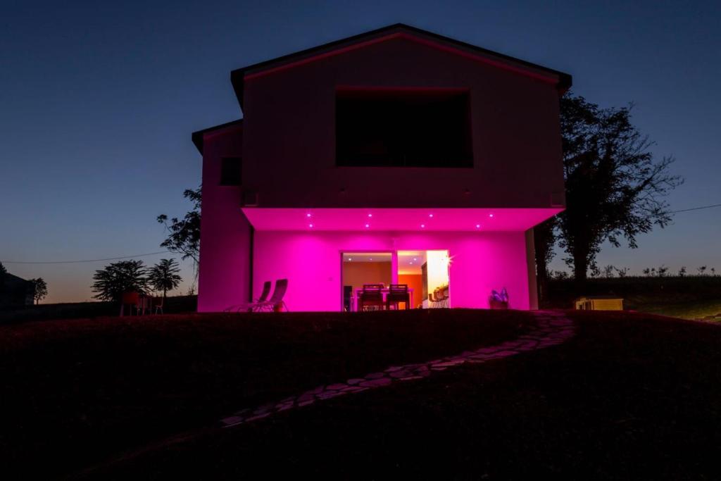 雷卡纳蒂Ritorno alla Natura的前面有紫色灯的房子