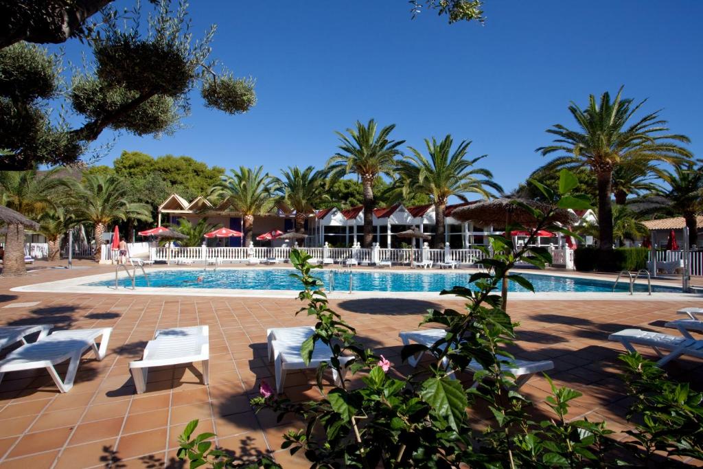 贝尼卡西姆Bonterra Resort的一个带躺椅的游泳池,棕榈树