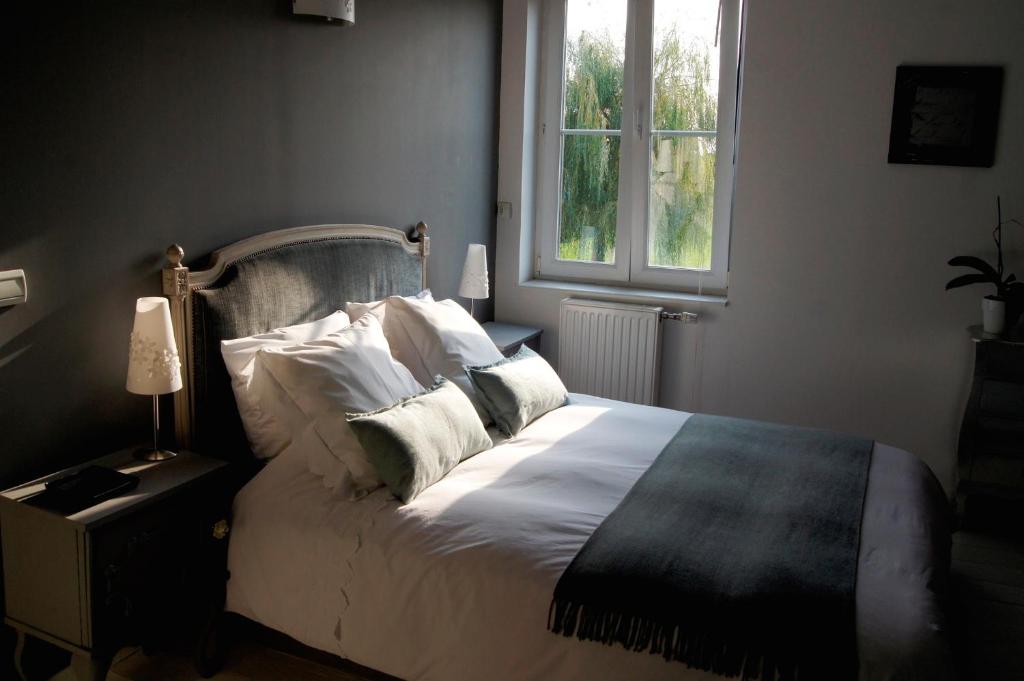 Wambrechies帕林特斯尚布里住宿加早餐旅馆的卧室配有带枕头的床铺和窗户。