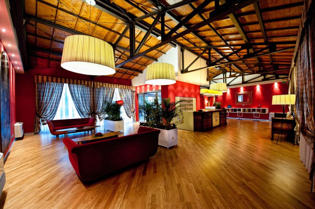 卡尔塔吉罗Hotel Villa Sturzo的大型客厅设有红色的墙壁和木地板