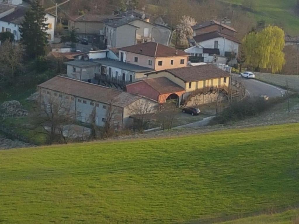 CasinaAgriturismo di Sordiglio的山丘上一群绿色的房屋