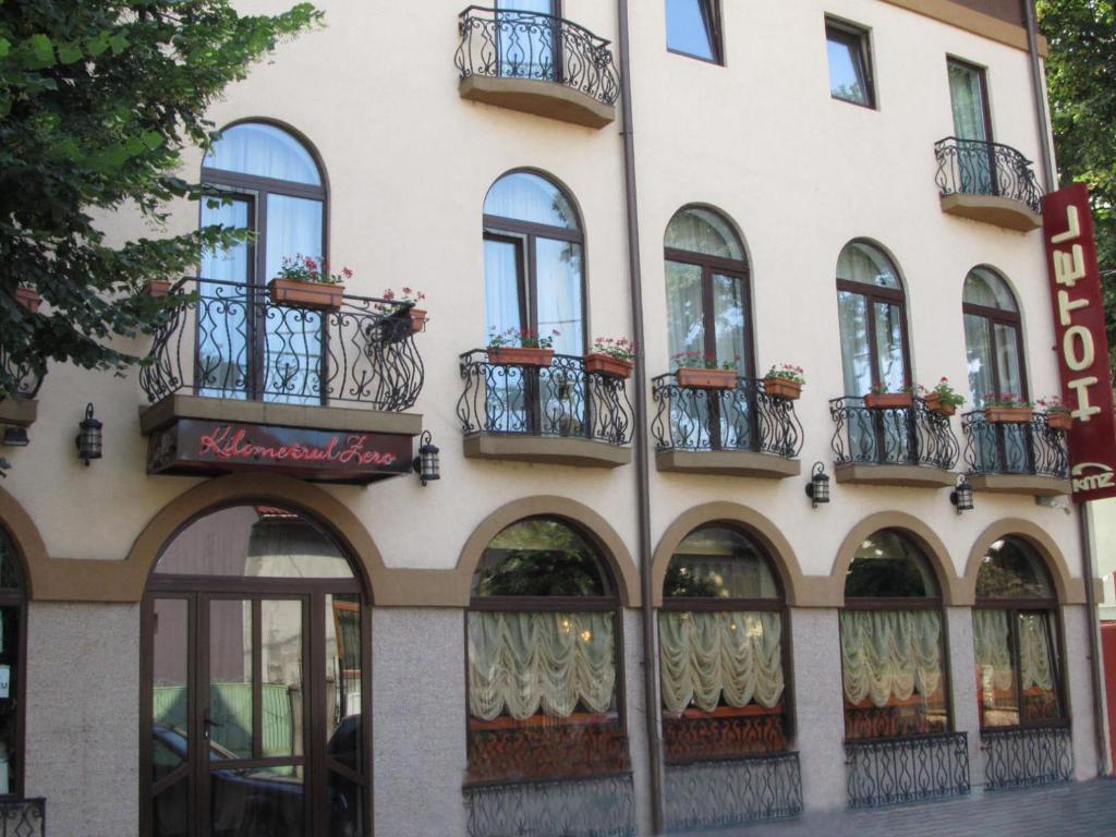 DrăgăşaniHotel Kilometrul Zero的街道上设有窗户和阳台的建筑