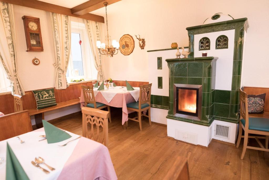 阿特斯特坦Schlossgasthof的一间带壁炉和桌椅的餐厅