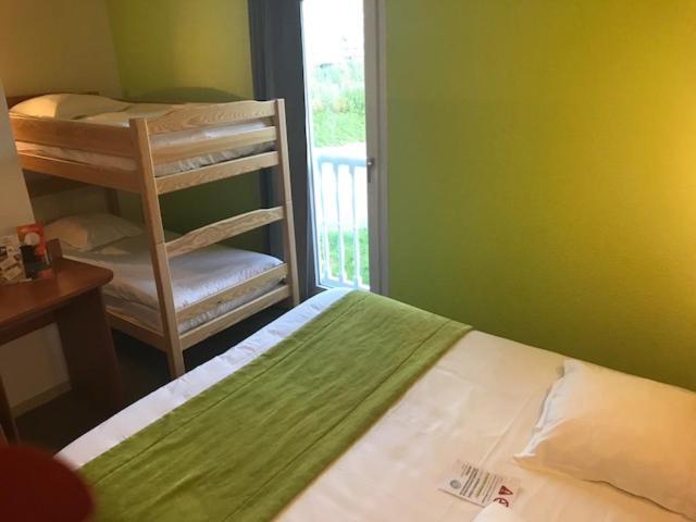 拉查佩里圣鲁布里特鲁瓦精萃机场酒店的一间卧室配有一张床、一张双层床和一把椅子