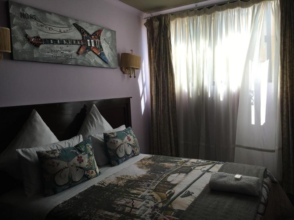肯普顿帕克Tassili Lodge的一间卧室设有一张大床和窗户