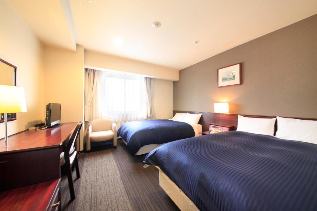 大垣昆泰撒大垣酒店的酒店客房设有两张床和电视。