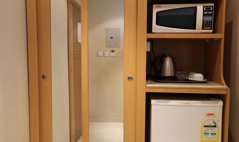 利雅德Meera Suites的一间带微波炉和冰箱的小厨房