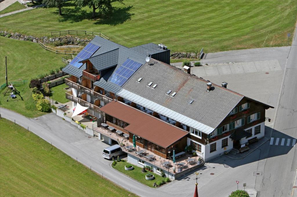 Sibratsgfäll赫斯臣旅馆的享有带太阳能屋顶房屋的空中景致