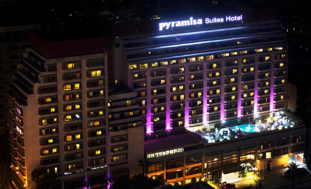 开罗开罗皮拉米萨套房酒店的一座晚上有紫色灯光的建筑