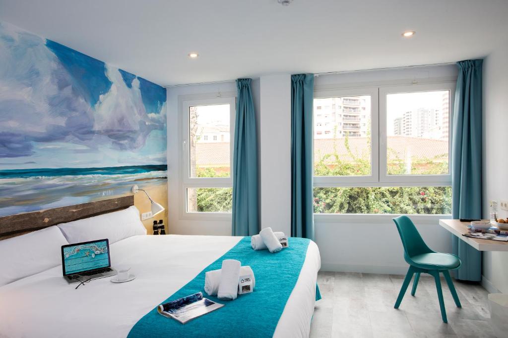 马拉加Casual del Mar Málaga的酒店客房设有一张床、一张书桌和窗户。