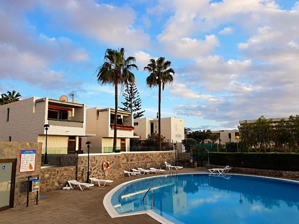 美洲海滩Lovely Apartment close to the Beach Apartamerica LA140的一个带椅子和棕榈树的大型游泳池