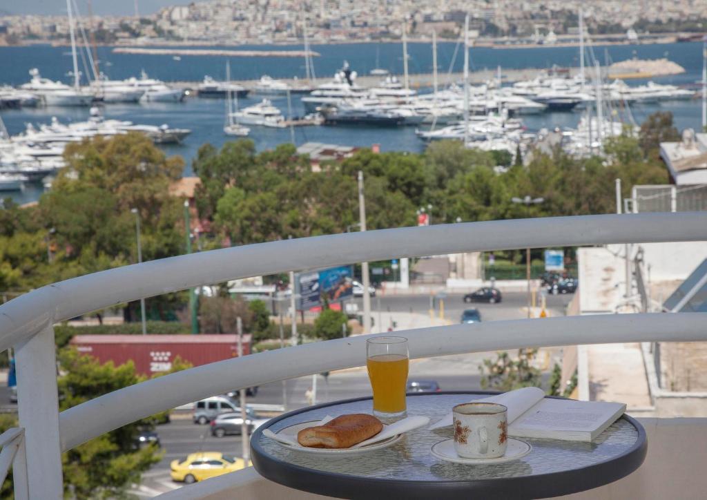 雅典尼斯海景优雅公寓的一张桌子,上面放着一盘食物和一杯橙汁