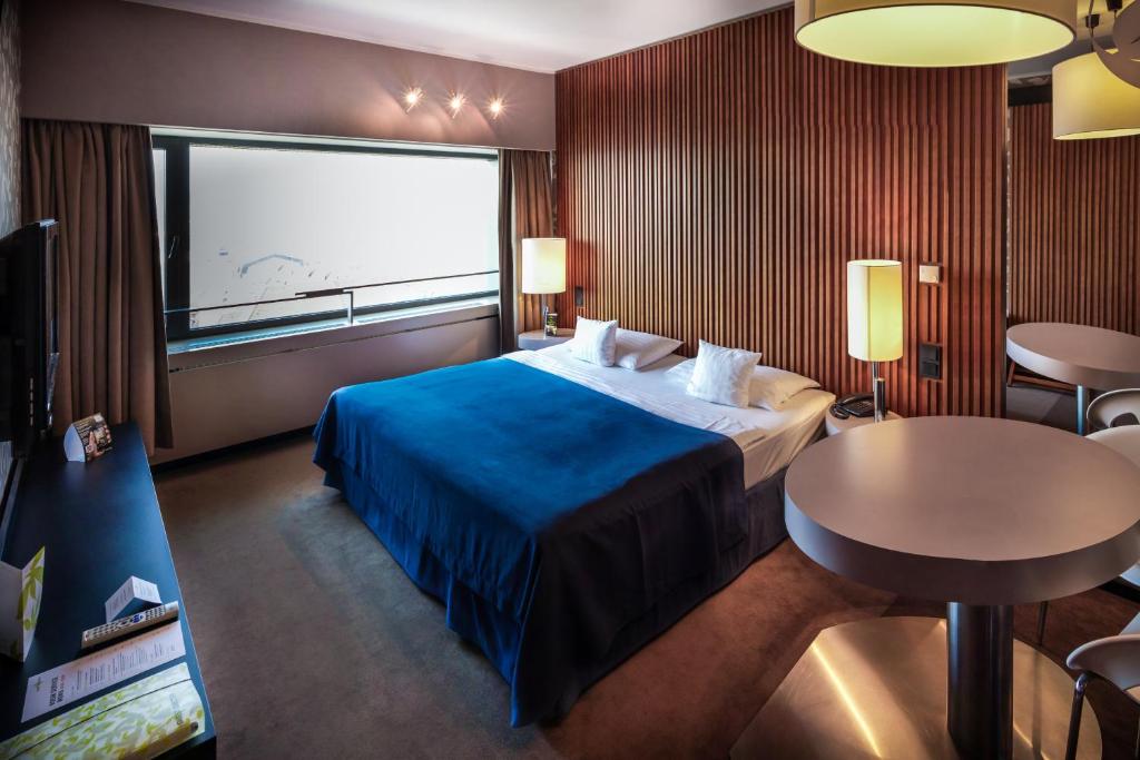 科希策优思明科希策酒店 的酒店客房设有一张大床和一张桌子。
