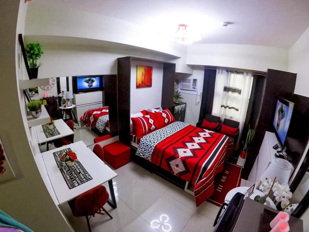 宿务Ezeniel's Place at Horizons 101 Condominium的一间卧室配有一张床、一张桌子和一张桌子