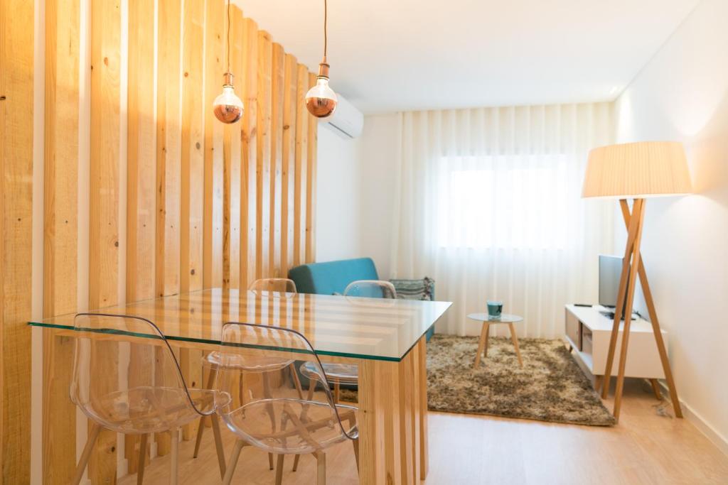 布拉加Bracara Guest House "D. Pedro V"的一间设有玻璃桌和椅子的用餐室