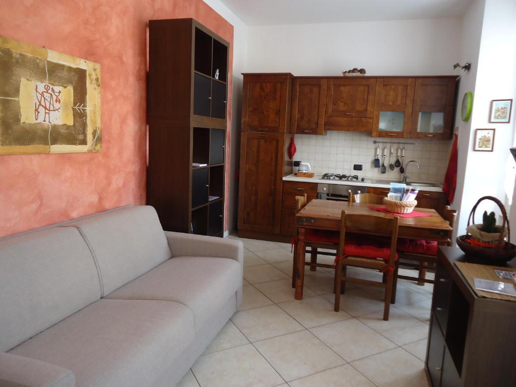 切尔诺比奥La Cà in piaza的带沙发和桌子的客厅以及厨房。