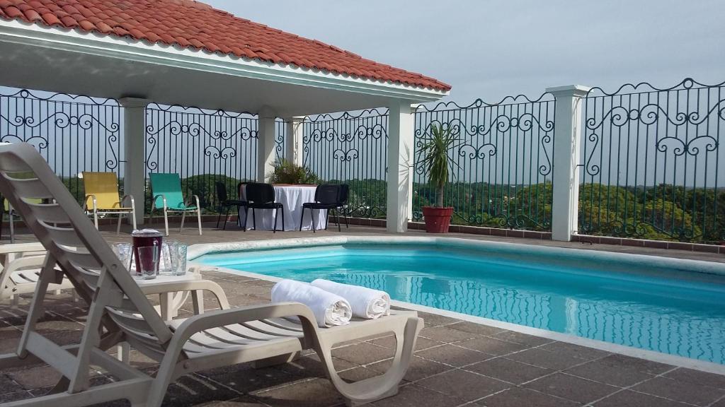 比亚埃尔莫萨瑞欧德拉果套房酒店的一个带两把椅子和一张桌子的游泳池