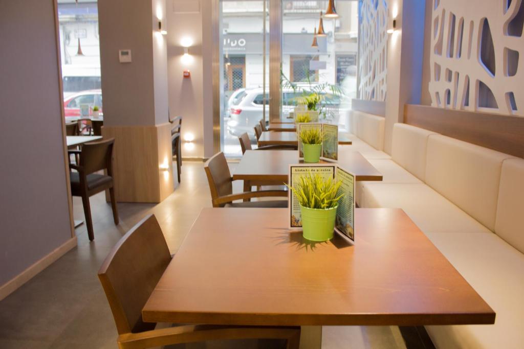 萨拉戈萨格兰大道酒店的餐馆里一排种着植物的桌子