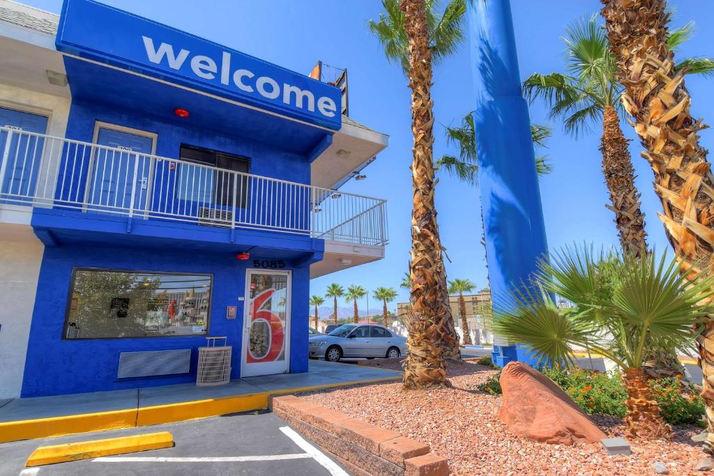 拉斯维加斯Motel 6-Las Vegas, NV - I-15 Stadium的一座蓝色的建筑,前面有棕榈树