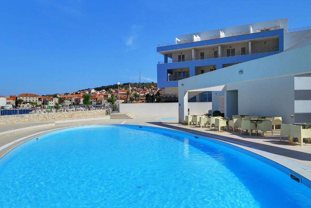 波斯蒂拉帕斯图拉酒店的一座大型蓝色游泳池,位于大楼旁边
