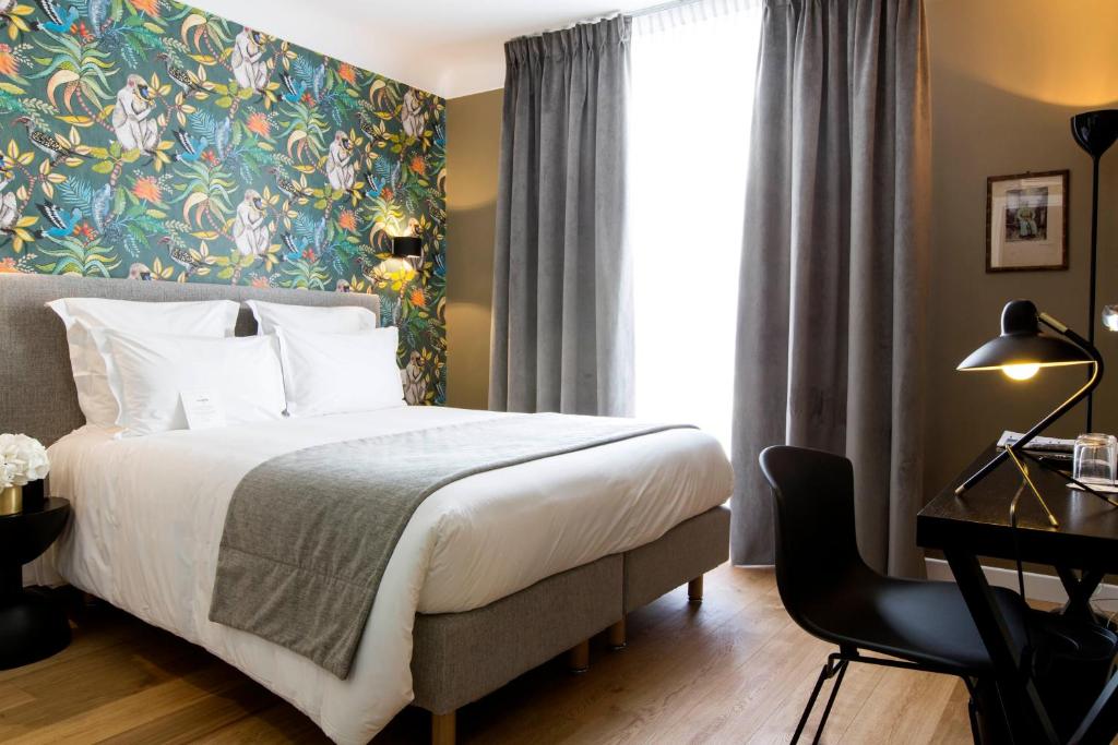 巴黎香榭丽舍大道马西斯酒店的配有一张床、一张书桌和一扇窗户的酒店客房