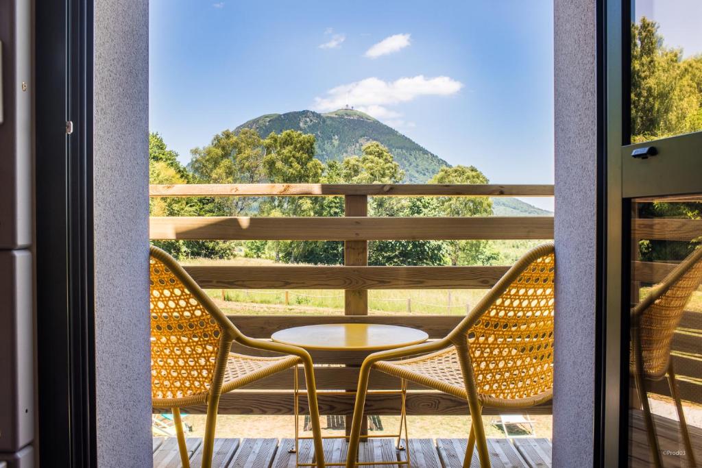 Saint-Genès-Champanelle群岛火山酒店的山景阳台上的桌椅