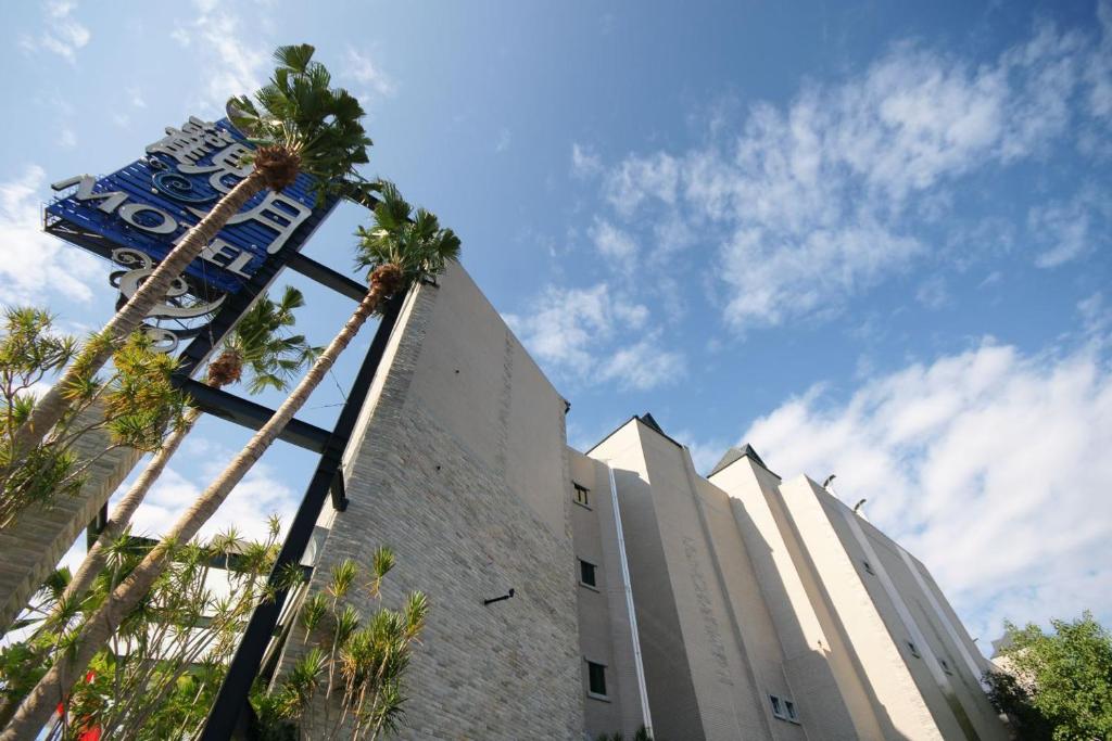 斗六市观月商务休闲旅馆的前面有棕榈树的建筑