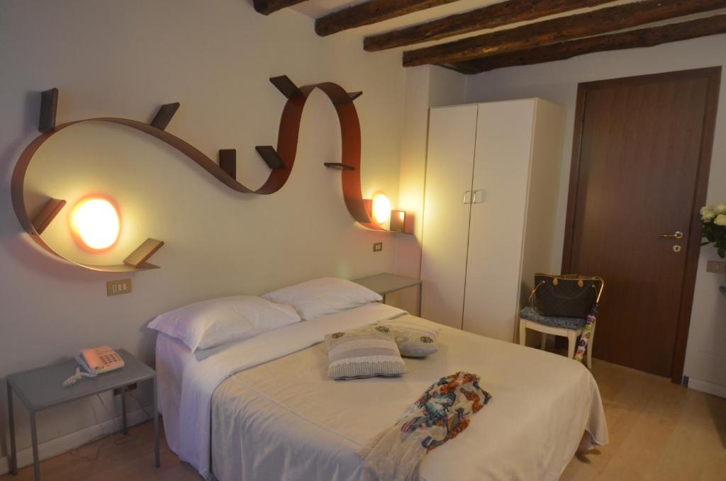 威尼斯小提埃波罗旅馆的卧室配有一张带镜子的白色大床