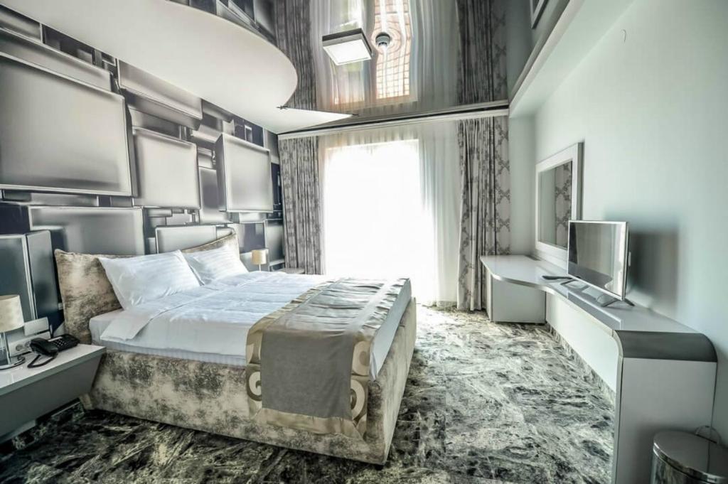 贝尔格莱德好莱坞康体中心及水上公园卡尔尼酒店的一间卧室配有一张大床和电视