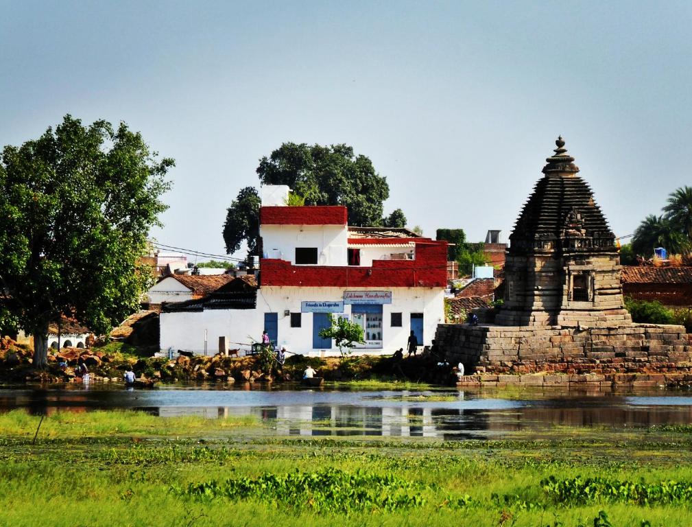 克久拉霍Friends in Khajuraho的水体旁边的建筑和寺庙